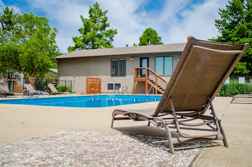 A chair is on the ground next to a pool.