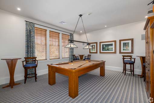 A room with a pool table and a chair.