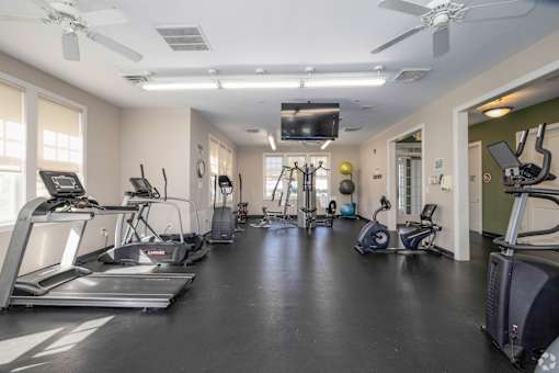 A spacious gym with treadmills, elliptical machines, and other exercise equipment.