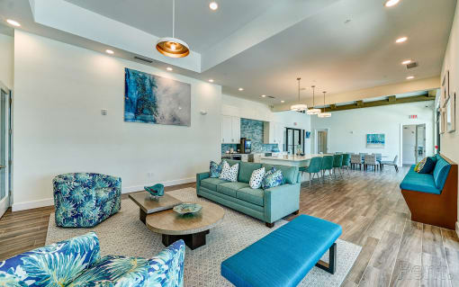 a large living room with blue couches and chairs and a kitchen with a bar at Imperial Crossing Luxury Apartment Homes, Bonita Springs, FL