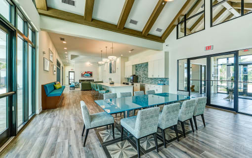 a dining room with blue tables and chairs and a kitchen with glass doors at Imperial Crossing Luxury Apartment Homes, Bonita Springs, FL, 34134