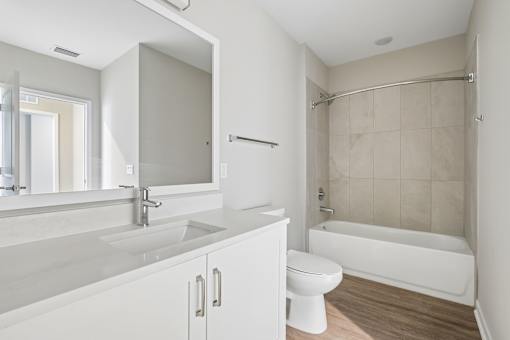 A white bathroom with a sink, toilet, and bathtub.