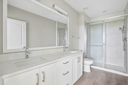 A white bathroom with a walk in shower.