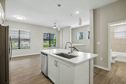 A kitchen with a white countertop and a black refrigerator.