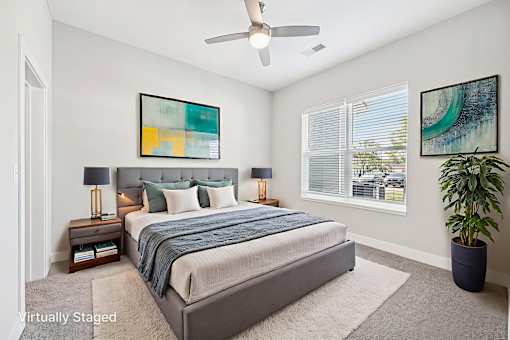 A bedroom with a large bed and a ceiling fan.