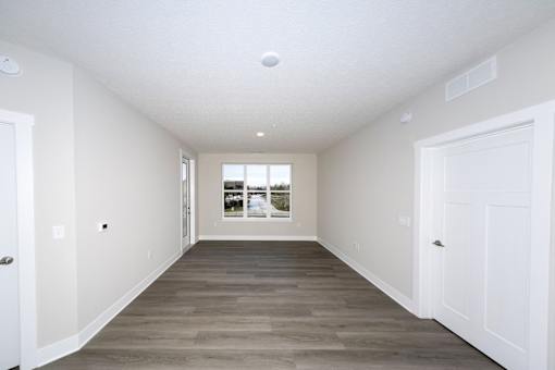 A long, empty hallway with white walls and a wooden floor.at Tiffany Flats, Columbus, OH, 43231
