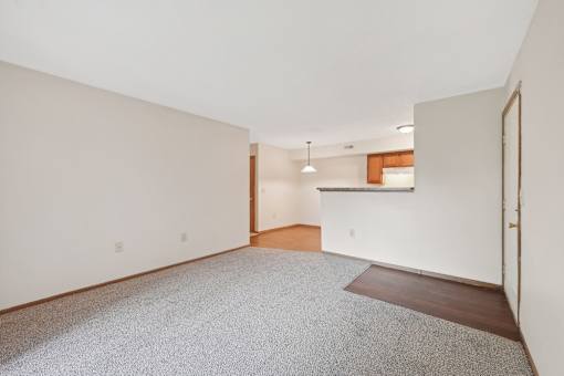 A room with a carpeted floor and a door on the right side.