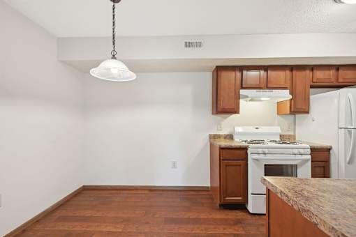A kitchen with a white stove and wooden cabinets.