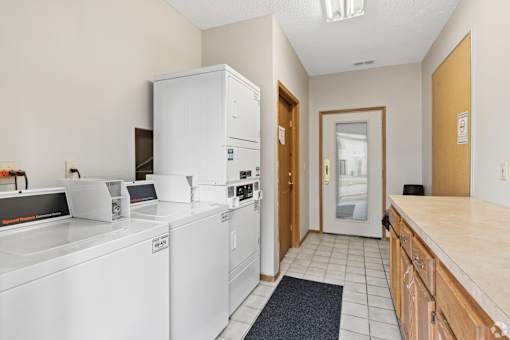 The clubhouse and leasing office at The Woods at McNeil Farms welcomes you! Enjoy amenities like a shared space, pool, and on-site laundry facility.