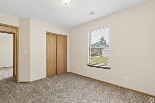 A carpeted bedroom of a home for rent at Cabot's Mill rental homes.