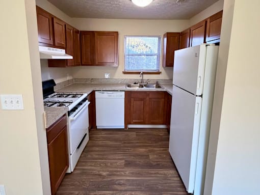 A kitchen with wooden cabinets and a white refrigerator.