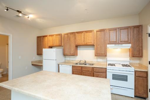 A kitchen with white appliances and wooden cabinets.
