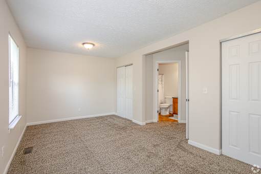 A room with a carpeted floor and white walls.