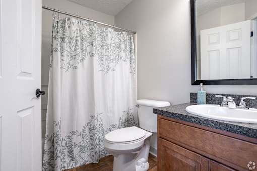 A white toilet sits next to a sink in a bathroom.
