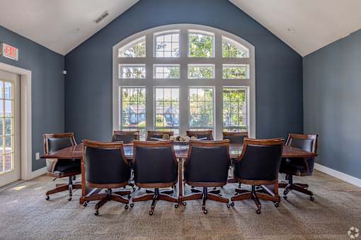 A conference room with a large table and chairs.