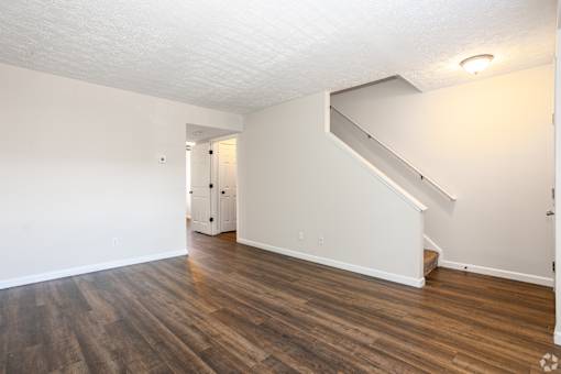 A room with a staircase and wood flooring.
