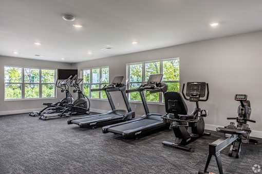 A spacious gym with treadmills and elliptical machines.