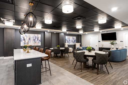 A modern dining area with a white counter and brown chairs.