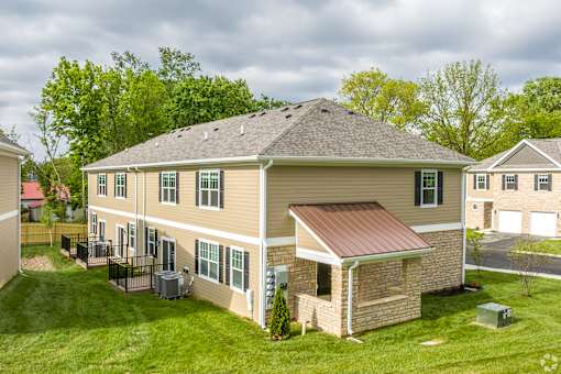 A house with a brown roof and a green lawn.
