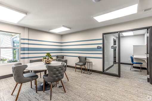 A conference room with a table, chairs, and a plant.