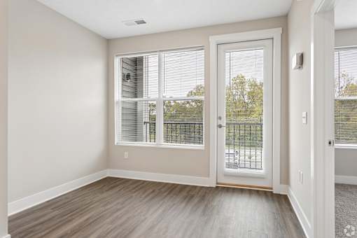A room with a sliding glass door leading to a balcony.