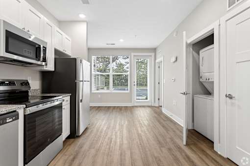 A kitchen with black appliances and white cabinets.