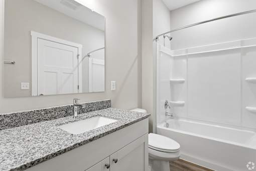 A bathroom with a sink, toilet, and bathtub.