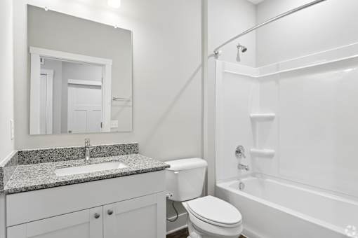 A white bathroom with a sink, toilet, and bathtub.