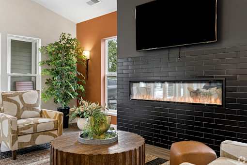 A living room with a fireplace and a flat screen TV mounted above it.