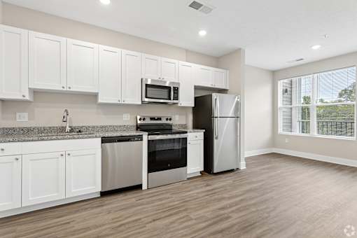 A kitchen with white cabinets and stainless steel appliances.