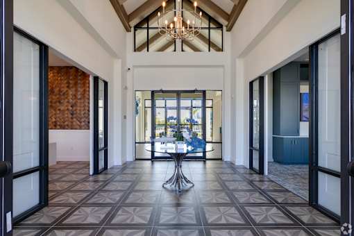 A large open hallway with a chandelier and a table in the middle.at Imperial Crossing Luxury Apartment Homes, Bonita Springs, FL