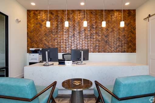 A reception area with a wooden wall and two chairs.at Imperial Crossing Luxury Apartment Homes, Bonita Springs, Florida