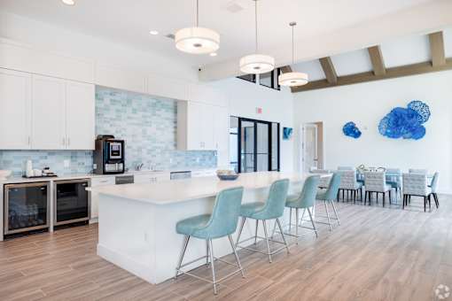 A kitchen with a white island and blue chairs.at Imperial Crossing Luxury Apartment Homes, Bonita Springs, FL