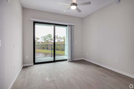 A room with a sliding glass door leading to a balcony.at Imperial Crossing Luxury Apartment Homes, Bonita Springs, FL, 34134