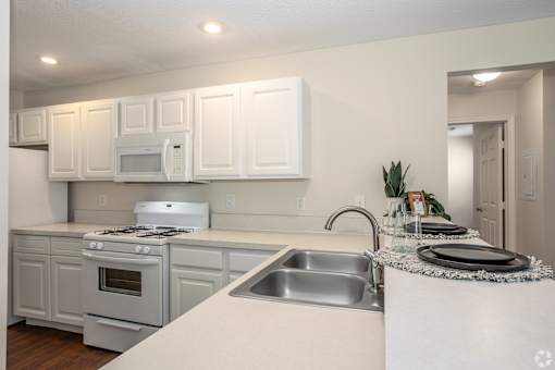 A kitchen with white cabinets and appliances.