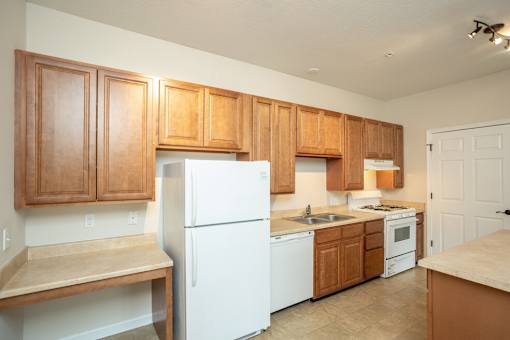 A kitchen with wooden cabinets and white appliances.