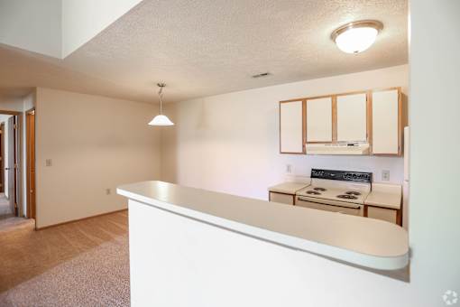 A white reception desk in a room with a cabinet and a microwave.