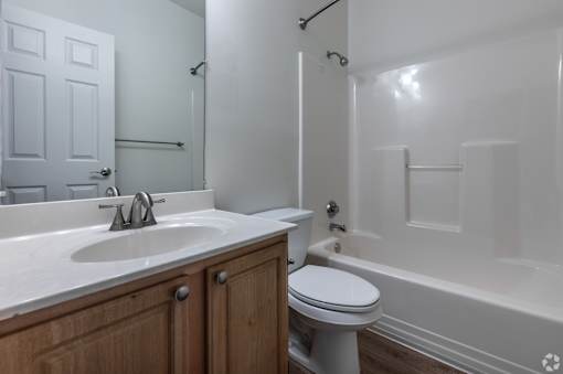 A white bathroom with a toilet, sink, and bathtub.