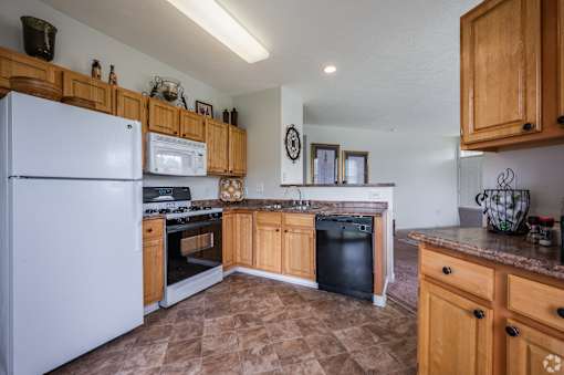 A kitchen with a white refrigerator and wooden cabinets.
