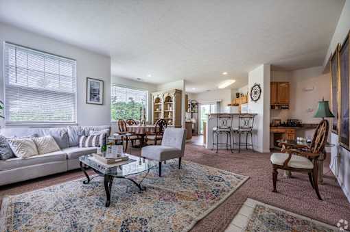 A living room with a couch, chairs, and a coffee table.