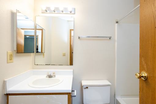 A white sink in a bathroom with a mirror above it.