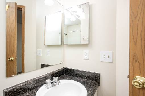 A bathroom with a sink and mirror.