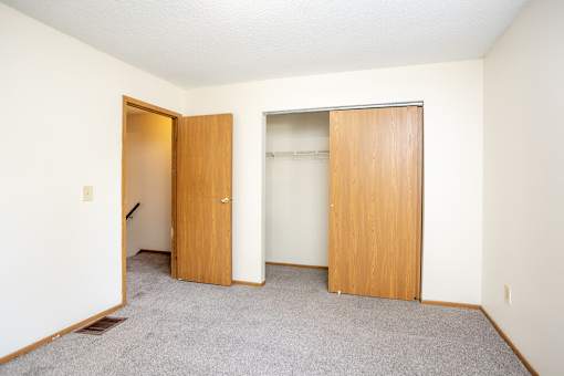 A room with two doors and a carpeted floor.