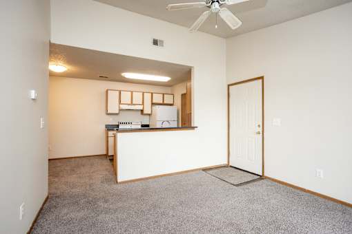A room with a white ceiling fan and a white door.