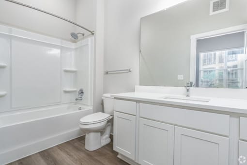 A white bathroom with a toilet, sink, and bathtub.