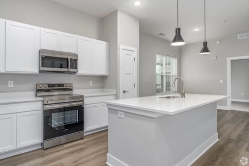 A modern kitchen with white cabinets and a large island.