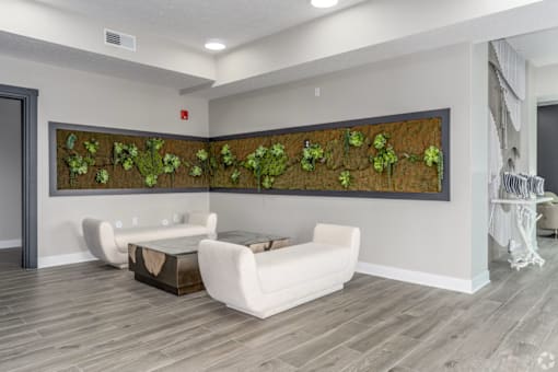 A living room with a green plant mural on the wall.