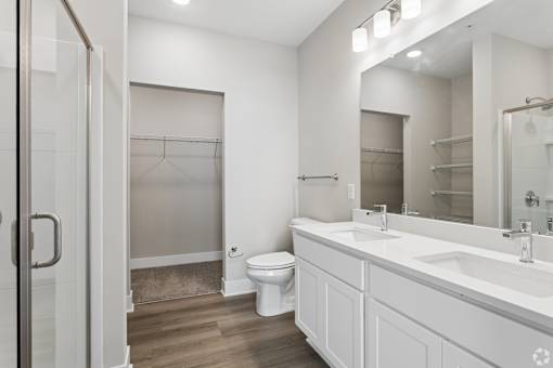 A white bathroom with a toilet, sink, and mirror.