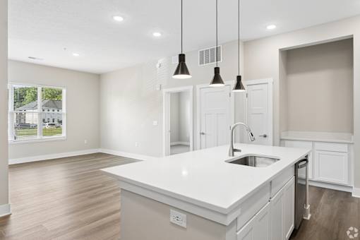 Kitchen with appliances and living area of an apartment home at Tiffany Flats in Columbus, OH.