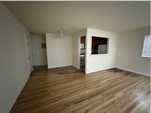 A room with wooden flooring and a window.